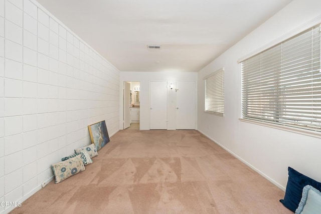 corridor featuring light colored carpet