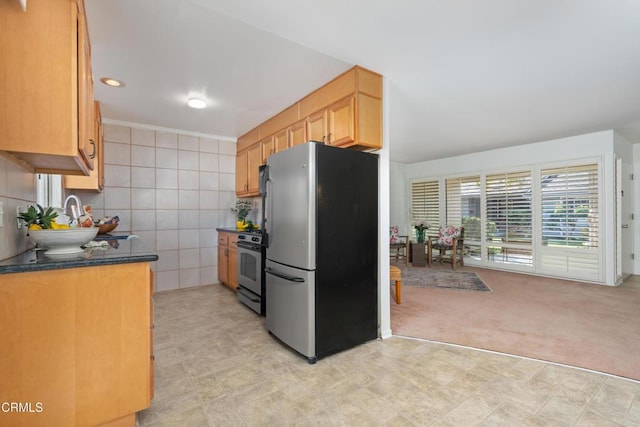 kitchen featuring appliances with stainless steel finishes, light carpet, and tile walls