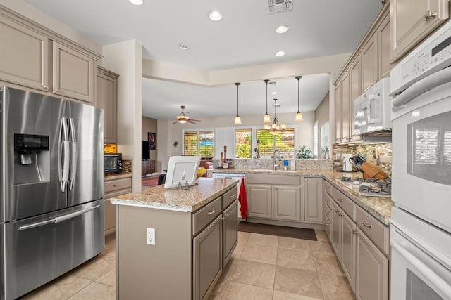 kitchen with appliances with stainless steel finishes, sink, decorative backsplash, a center island, and kitchen peninsula