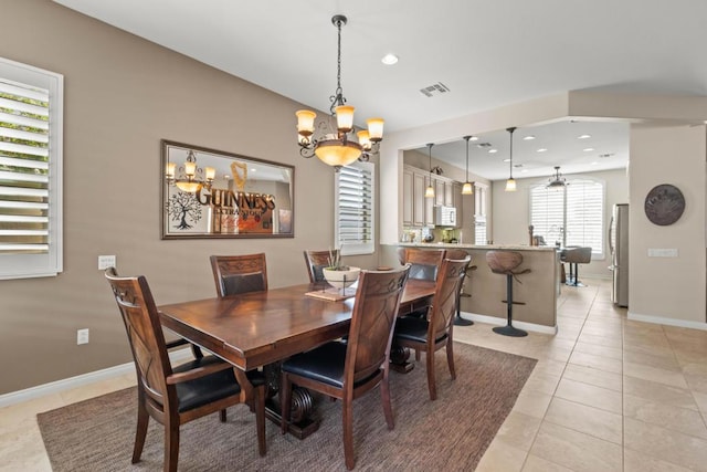 dining area featuring light tile patterned flooring and a chandelier