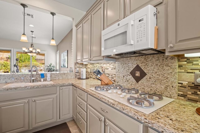 kitchen featuring sink, white appliances, an inviting chandelier, decorative backsplash, and decorative light fixtures