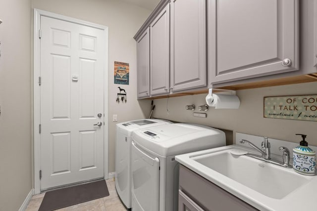 washroom with cabinets, washing machine and dryer, and sink