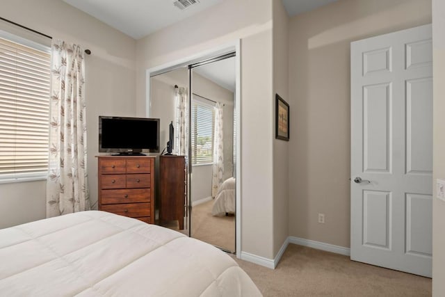 bedroom with light colored carpet and a closet