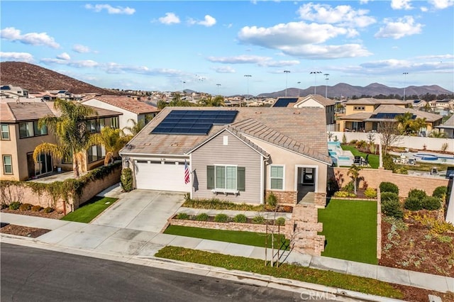 view of front facade with a mountain view, a garage, and solar panels