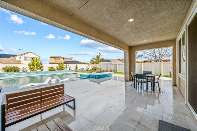 view of patio / terrace with a swimming pool with hot tub