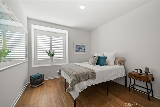 bedroom with multiple windows and hardwood / wood-style flooring