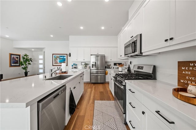 kitchen with white cabinetry, sink, a center island with sink, and appliances with stainless steel finishes