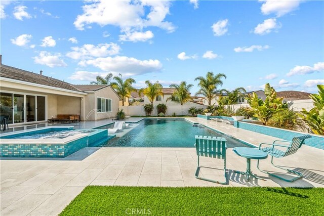 view of swimming pool featuring a patio area and an in ground hot tub