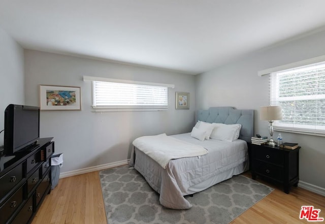 bedroom with multiple windows and light hardwood / wood-style floors