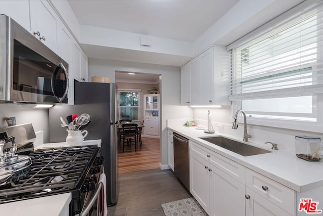 kitchen with stainless steel appliances, dark hardwood / wood-style flooring, sink, and white cabinets