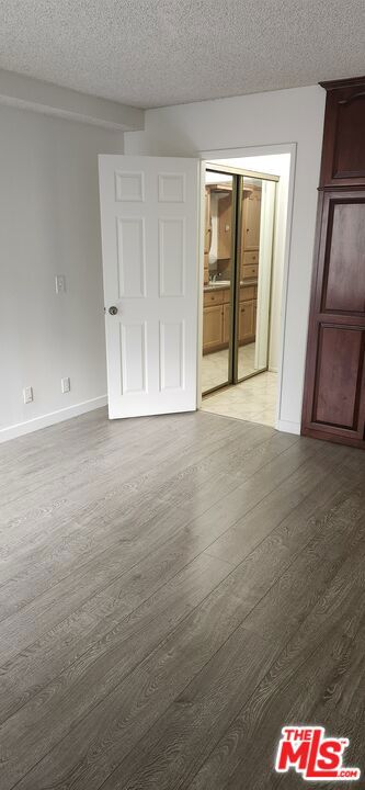 spare room featuring wood-type flooring and a textured ceiling