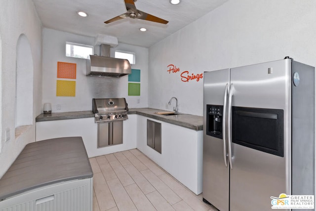 kitchen with sink, white cabinets, stainless steel fridge, exhaust hood, and ceiling fan