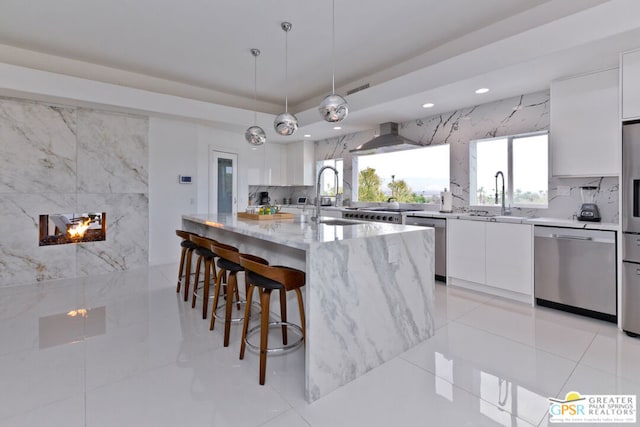 kitchen with light stone countertops, a center island, stainless steel dishwasher, and white cabinets