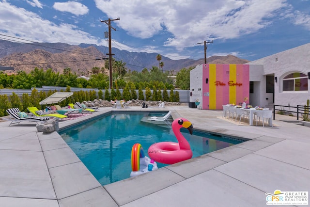 view of pool with a mountain view and a patio area