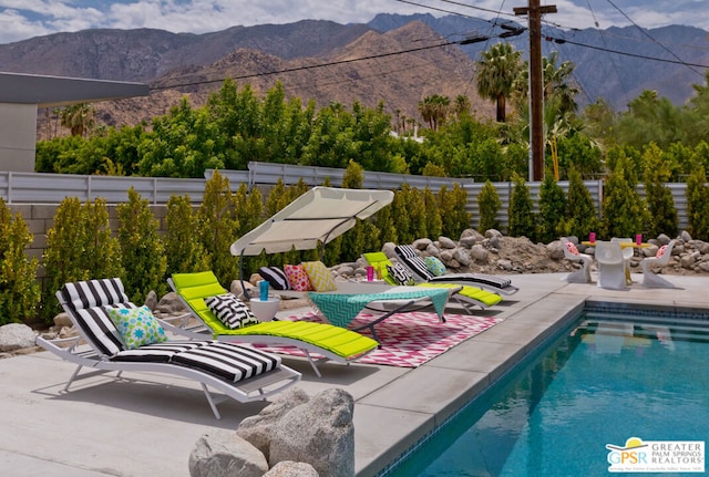 view of pool featuring a mountain view and a patio