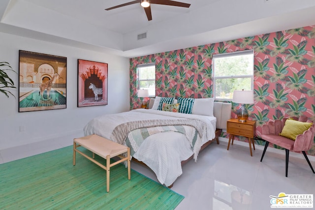 bedroom with ceiling fan and a tray ceiling