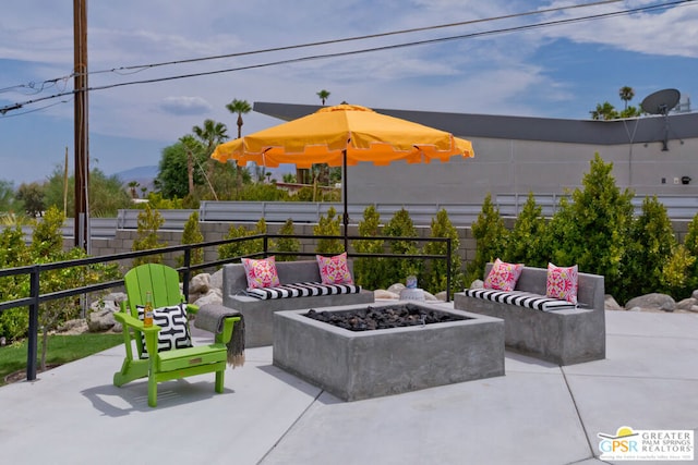 view of patio with an outdoor living space with a fire pit