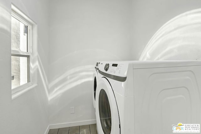 clothes washing area with a wealth of natural light, washer and dryer, and wood-type flooring