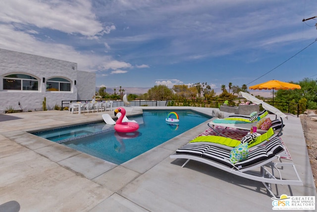 view of swimming pool with a patio and an in ground hot tub