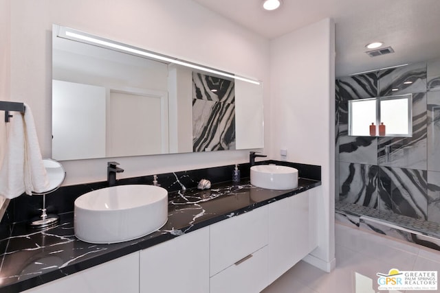 bathroom with vanity and tiled shower