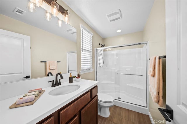 bathroom with vanity, toilet, a shower with shower door, and wood-type flooring