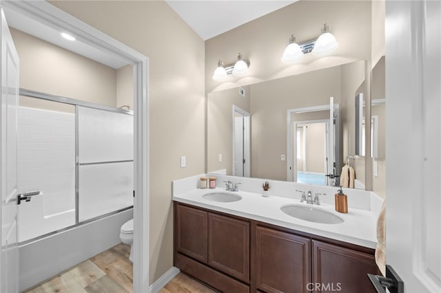 full bathroom with toilet, vanity, shower / bath combination with glass door, and hardwood / wood-style floors