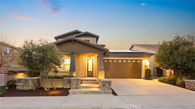 craftsman inspired home featuring a garage and solar panels