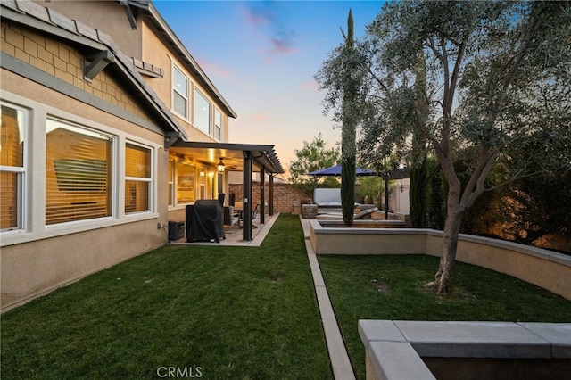 yard at dusk featuring a patio and a pergola