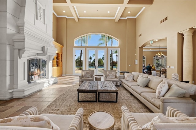 tiled living room with an inviting chandelier, beam ceiling, a high ceiling, coffered ceiling, and a large fireplace