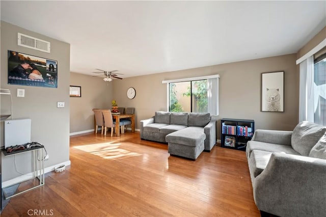 living room featuring wood-type flooring and ceiling fan