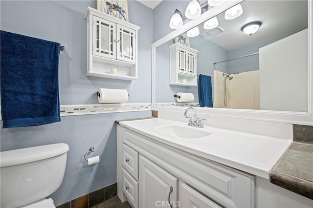 bathroom featuring vanity, toilet, and a shower