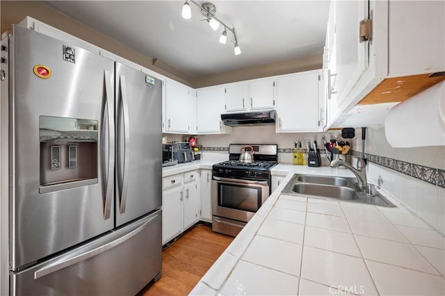 kitchen with white cabinetry, appliances with stainless steel finishes, sink, and tile countertops