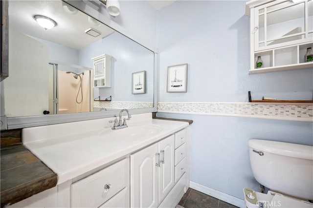 bathroom featuring vanity, an enclosed shower, and toilet