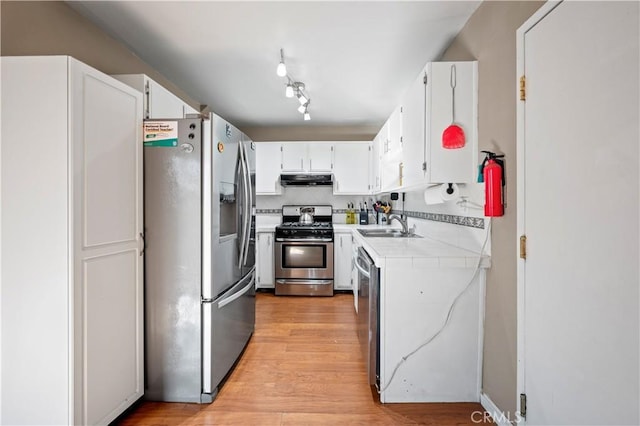 kitchen with white cabinetry, tasteful backsplash, stainless steel appliances, and light hardwood / wood-style floors