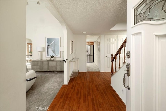 hall featuring dark wood-type flooring and a textured ceiling