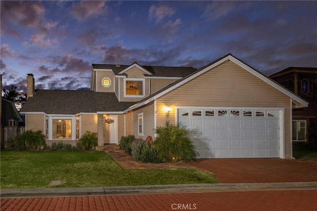 front of property featuring a yard and a garage