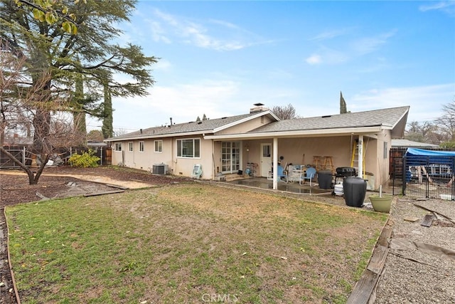 rear view of house featuring a patio, central AC unit, and a lawn