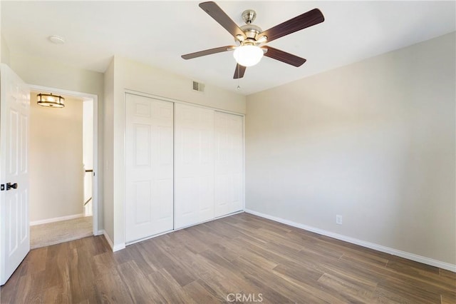 unfurnished bedroom featuring ceiling fan, hardwood / wood-style floors, and a closet