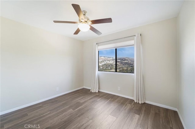 unfurnished room with dark wood-type flooring and ceiling fan