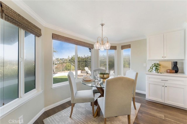 dining area featuring dark hardwood / wood-style flooring, crown molding, and an inviting chandelier