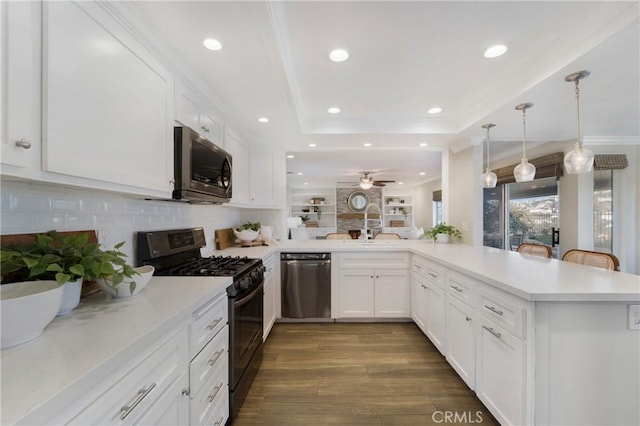 kitchen with pendant lighting, stainless steel appliances, a tray ceiling, white cabinets, and kitchen peninsula