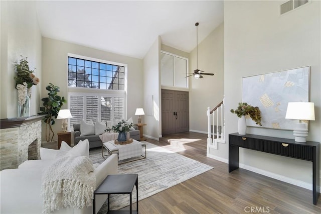 living room featuring dark wood-type flooring, high vaulted ceiling, and ceiling fan