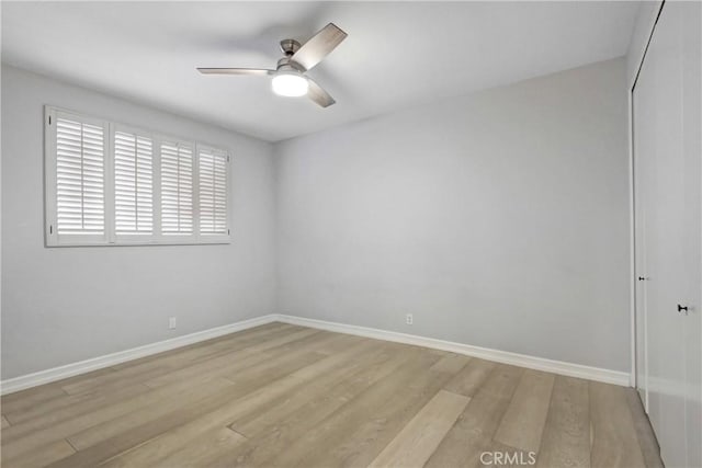 spare room with ceiling fan and light wood-type flooring