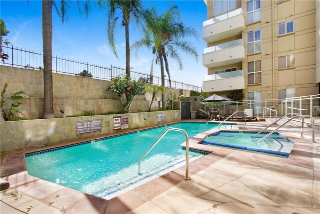 view of pool featuring a community hot tub and a patio area