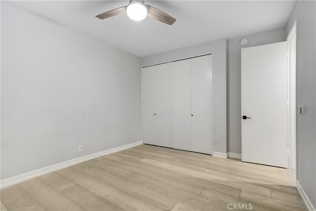 unfurnished bedroom featuring a closet, ceiling fan, and light hardwood / wood-style flooring