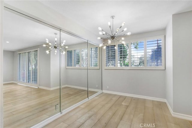 unfurnished bedroom with light wood-type flooring and a chandelier