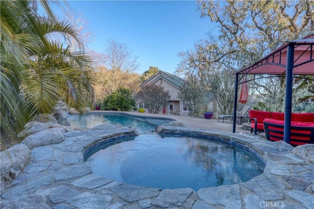 view of swimming pool with an in ground hot tub, outdoor lounge area, and a patio area