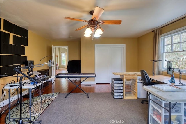 office area with ceiling fan and dark hardwood / wood-style floors