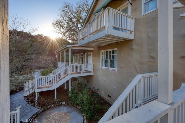 property exterior at dusk with a balcony