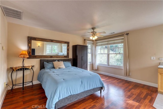 bedroom featuring multiple windows, dark hardwood / wood-style floors, and ceiling fan